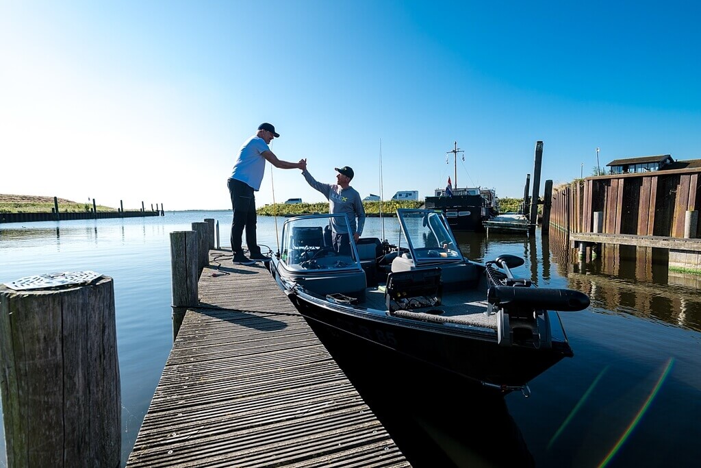 Angelguide Robin Grompe auf Boot mit Kunden am Steg